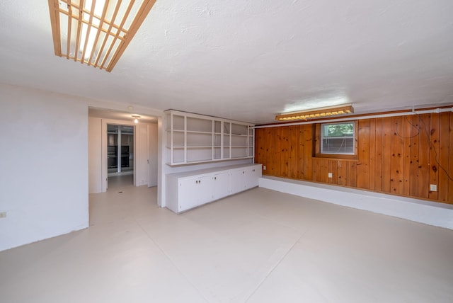 106 Rust Ave, Big Rapids, MI 49307 - empty room with finished concrete floors and wood walls