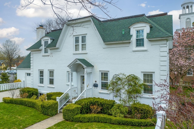106 Rust Ave, Big Rapids, MI 49307 - view of front of home with a chimney, brick siding, and a shingled roof