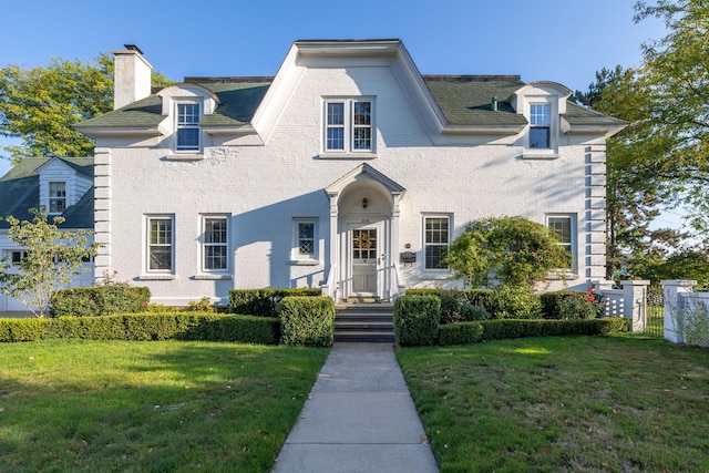 106 Rust Ave, Big Rapids, MI 49307 - view of front of house with a chimney, a front lawn, and brick siding