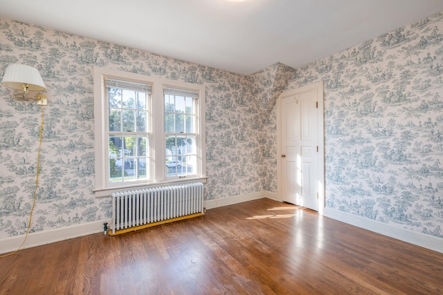 106 Rust Ave, Big Rapids, MI 49307 - empty room featuring radiator heating unit, wood finished floors, and wallpapered walls