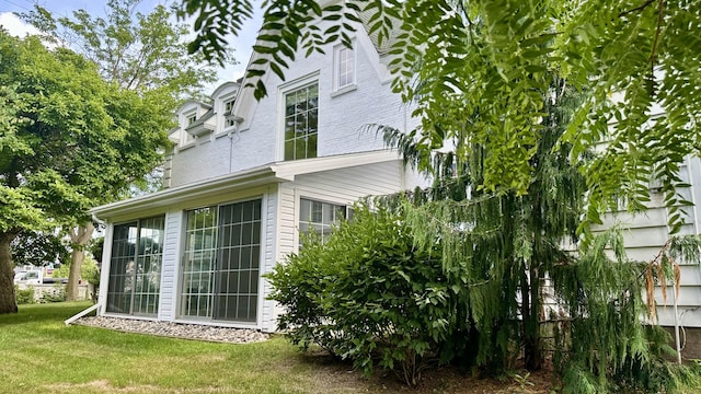 106 Rust Ave, Big Rapids, MI 49307 - view of side of home featuring a lawn and a sunroom