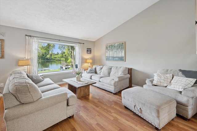 1393 Shankin Dr, Walled Lake, MI 48390 - living area featuring light wood-type flooring, lofted ceiling, a textured ceiling, and a water view
