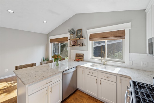 1393 Shankin Dr, Walled Lake, MI 48390 - kitchen with stainless steel dishwasher, range, a peninsula, lofted ceiling, and tasteful backsplash