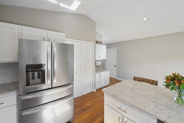 1393 Shankin Dr, Walled Lake, MI 48390 - kitchen featuring stainless steel fridge, vaulted ceiling, decorative backsplash, white cabinetry, and wood finished floors