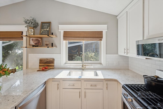 1393 Shankin Dr, Walled Lake, MI 48390 - kitchen featuring appliances with stainless steel finishes, vaulted ceiling, open shelves, white cabinetry, and backsplash