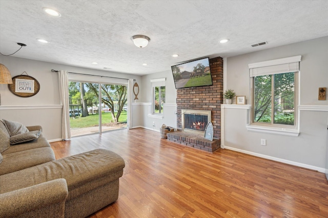 1393 Shankin Dr, Walled Lake, MI 48390 - living room with a textured ceiling, wood finished floors, recessed lighting, and a fireplace