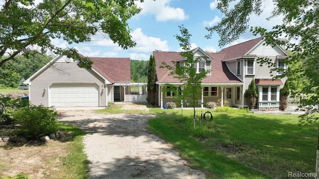 3733 N Hoover Ave, Gladwin, MI 48624 - view of front of house featuring dirt driveway, an attached garage, and a front yard