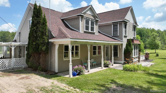 3733 N Hoover Ave, Gladwin, MI 48624 - view of front of house featuring a front yard, roof with shingles, and a patio