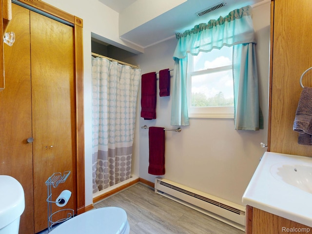 3733 N Hoover Ave, Gladwin, MI 48624 - bathroom with a baseboard heating unit, wood finished floors, vanity, and curtained shower