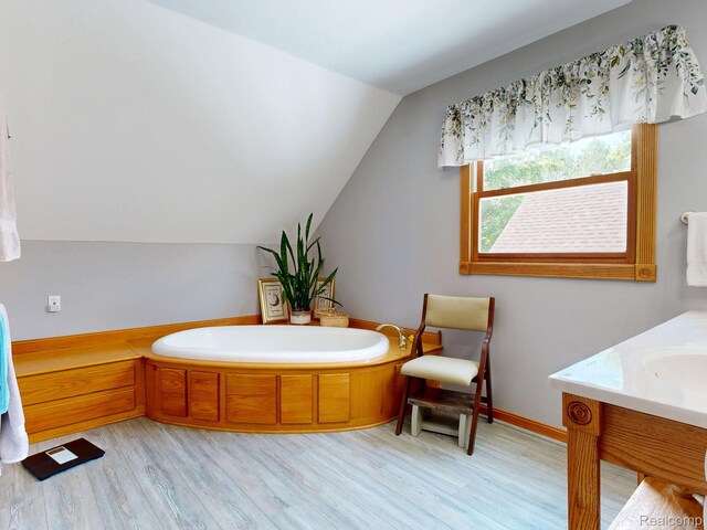3733 N Hoover Ave, Gladwin, MI 48624 - bathroom featuring wood finished floors, a bath, lofted ceiling, and vanity