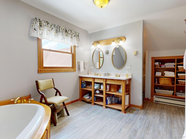 3733 N Hoover Ave, Gladwin, MI 48624 - bathroom with baseboard heating, double vanity, a tub, and wood finished floors