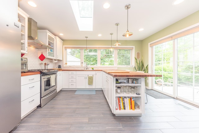 2100 Alice St, Ann Arbor, MI 48103 - kitchen featuring wall chimney range hood, appliances with stainless steel finishes, butcher block countertops, open shelves, and recessed lighting