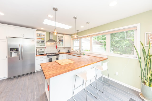 2100 Alice St, Ann Arbor, MI 48103 - kitchen with stainless steel appliances, butcher block counters, wood finished floors, a skylight, and glass insert cabinets