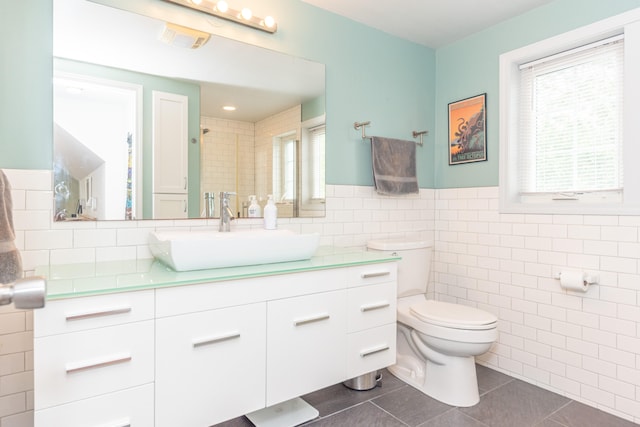 2100 Alice St, Ann Arbor, MI 48103 - bathroom with tile walls, tile patterned floors, vanity, and a wainscoted wall
