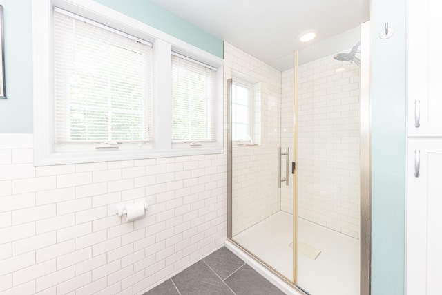 2100 Alice St, Ann Arbor, MI 48103 - bathroom with tile walls, tile patterned floors, a stall shower, and wainscoting