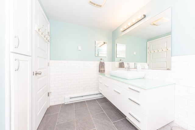 2100 Alice St, Ann Arbor, MI 48103 - bathroom featuring tile walls, a baseboard heating unit, vanity, a wainscoted wall, and tile patterned floors
