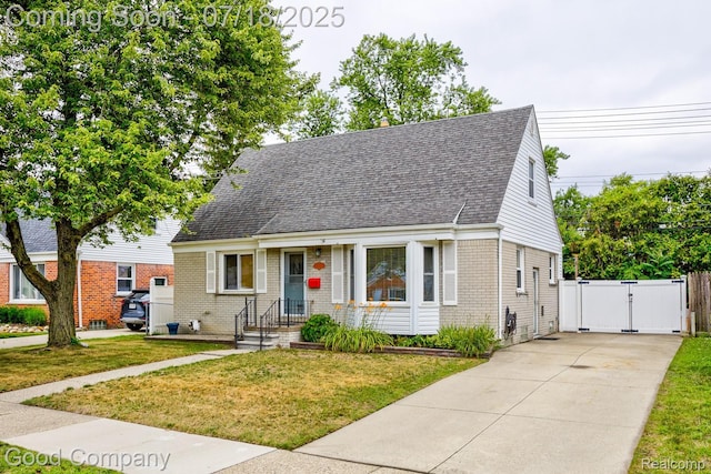 923 E 4th St, Royal Oak, MI 48067 - new england style home featuring a gate, brick siding, driveway, and roof with shingles