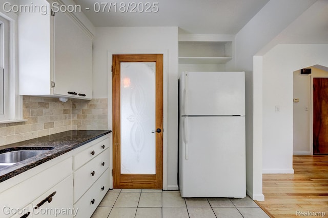 923 E 4th St, Royal Oak, MI 48067 - kitchen featuring freestanding refrigerator, white cabinetry, dark stone counters, tasteful backsplash, and light tile patterned floors