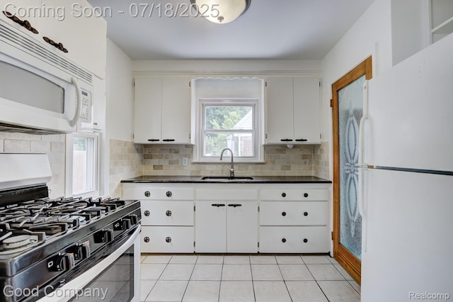 923 E 4th St, Royal Oak, MI 48067 - kitchen featuring white appliances, dark countertops, tasteful backsplash, and white cabinetry