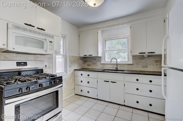923 E 4th St, Royal Oak, MI 48067 - kitchen featuring white appliances, light tile patterned flooring, white cabinetry, and decorative backsplash