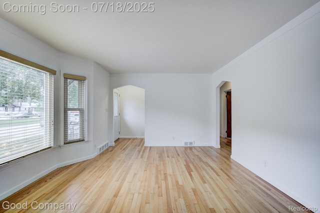 923 E 4th St, Royal Oak, MI 48067 - empty room featuring arched walkways, hardwood / wood-style floors, and ornamental molding