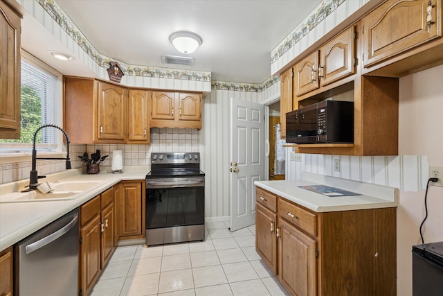 11 Geiger Ave, Battle Creek, MI 49037 - kitchen with appliances with stainless steel finishes, light countertops, decorative backsplash, light tile patterned floors, and brown cabinets