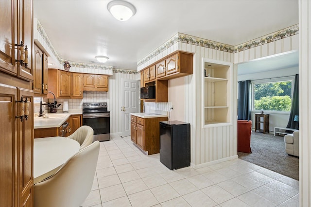 11 Geiger Ave, Battle Creek, MI 49037 - kitchen featuring stainless steel range with electric stovetop, light countertops, light tile patterned floors, and wallpapered walls