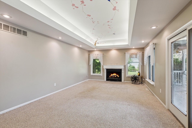 11 Geiger Ave, Battle Creek, MI 49037 - unfurnished living room featuring light carpet, a raised ceiling, recessed lighting, and a fireplace with flush hearth