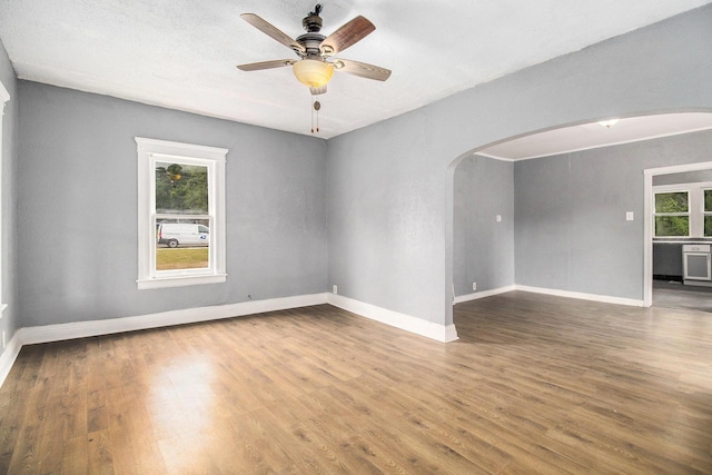 1850 S Burdick St, Kalamazoo, MI 49001 - empty room with arched walkways, wood finished floors, and a ceiling fan