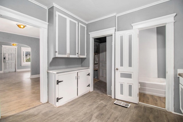 1850 S Burdick St, Kalamazoo, MI 49001 - interior space with light countertops, crown molding, light wood-type flooring, white cabinetry, and arched walkways