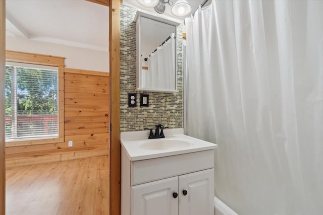 222 E Mill St, Hastings, MI 49058 - full bathroom featuring vanity, backsplash, a shower with shower curtain, wood finished floors, and wooden walls