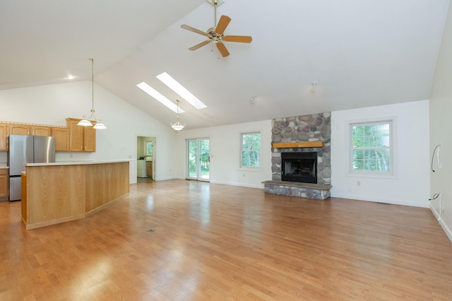 1803 Bell Rd, Niles, MI 49120 - unfurnished living room with high vaulted ceiling, a ceiling fan, healthy amount of natural light, a fireplace, and light wood finished floors