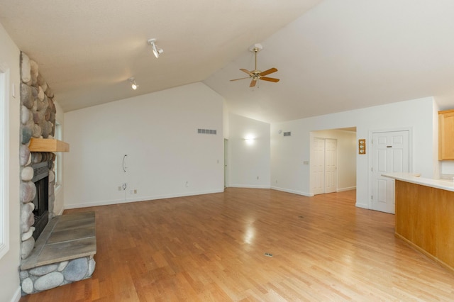 1803 Bell Rd, Niles, MI 49120 - unfurnished living room featuring a ceiling fan, vaulted ceiling, a stone fireplace, and light wood-type flooring