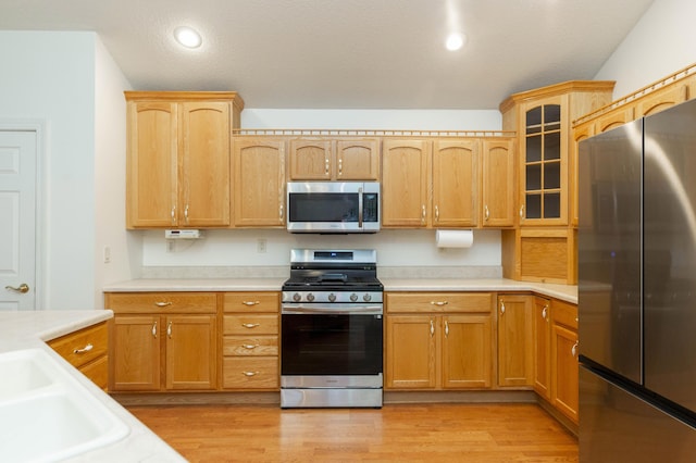 1803 Bell Rd, Niles, MI 49120 - kitchen featuring appliances with stainless steel finishes, light countertops, glass insert cabinets, light wood finished floors, and recessed lighting