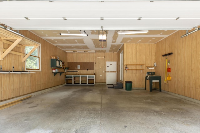 1803 Bell Rd, Niles, MI 49120 - garage featuring a garage door opener, wooden walls, and freestanding refrigerator