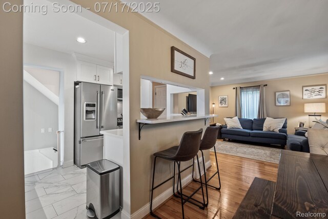 309 S Dorchester Ave, Royal Oak, MI 48067 - kitchen with high end refrigerator, a kitchen breakfast bar, open floor plan, white cabinets, and light countertops