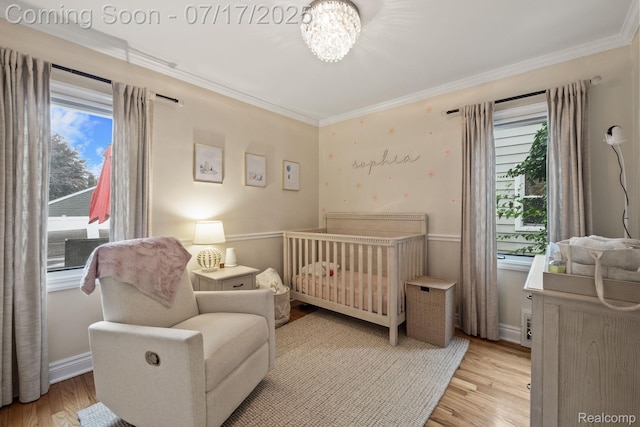 309 S Dorchester Ave, Royal Oak, MI 48067 - bedroom featuring multiple windows, a nursery area, crown molding, and light wood-style flooring