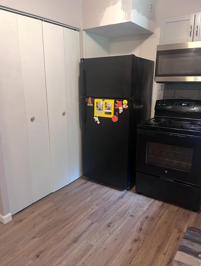 2032 Daron Pl, Flint, MI 48505 - kitchen with black appliances, light wood-style flooring, and white cabinetry