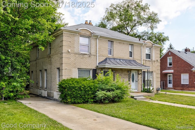 21797 Moross Rd, Grosse Pointe, MI 48236 - traditional-style house with a front yard, a chimney, brick siding, and a standing seam roof