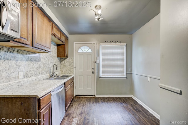 21797 Moross Rd, Grosse Pointe, MI 48236 - kitchen with stainless steel appliances, dark wood finished floors, backsplash, light countertops, and brown cabinets