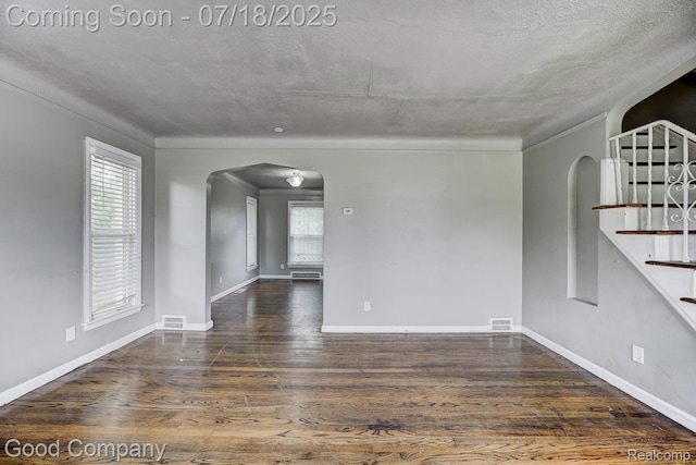 21797 Moross Rd, Grosse Pointe, MI 48236 - unfurnished room with arched walkways, a textured ceiling, wood finished floors, stairs, and crown molding