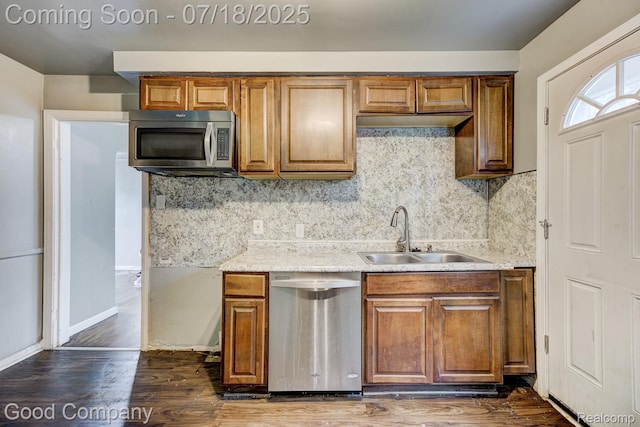 21797 Moross Rd, Grosse Pointe, MI 48236 - kitchen featuring stainless steel appliances, backsplash, brown cabinets, dark wood-style flooring, and light stone countertops