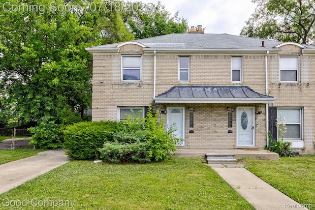 21797 Moross Rd, Grosse Pointe, MI 48236 - traditional-style home featuring brick siding, a front yard, a chimney, and a standing seam roof