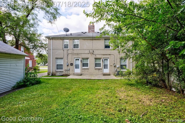 21797 Moross Rd, Grosse Pointe, MI 48236 - back of house featuring a patio, a lawn, brick siding, and a chimney