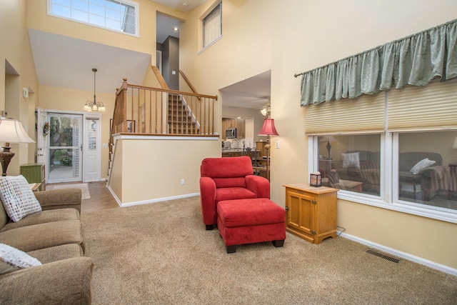 3542 Kirkaldy Cir, Portage, MI 49024 - living room featuring a high ceiling, carpet flooring, stairway, and a chandelier
