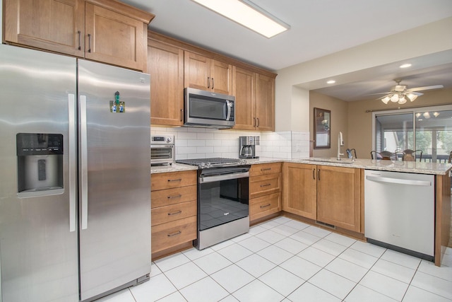 3542 Kirkaldy Cir, Portage, MI 49024 - kitchen with stainless steel appliances, a peninsula, decorative backsplash, light stone countertops, and recessed lighting