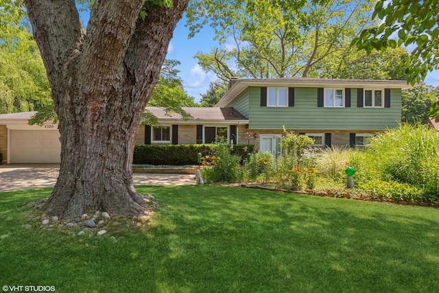 1320 S Manor Dr, Saint Joseph, MI 49085 - tri-level home featuring a front lawn, an attached garage, and concrete driveway