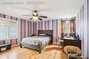 402 Thomas Ln, Grand Blanc, MI 48439 - bedroom featuring wallpapered walls, wood finished floors, and a ceiling fan