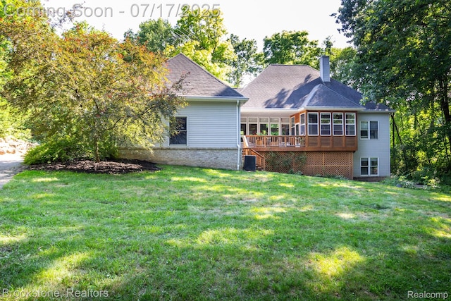 8808 Big Lake Rd, Clarkston, MI 48346 - rear view of property with a sunroom, a chimney, a yard, and a wooden deck