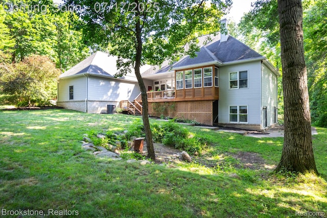 8808 Big Lake Rd, Clarkston, MI 48346 - rear view of property with a sunroom, a chimney, a yard, and a wooden deck